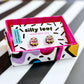 Mr Blobby stud earrings displayed on a white card with Silly Loaf branding and a sticker that says "hypoallergenic stainless steel". The card is presented in a colourful gift box.