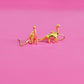 Gold dinosaur shaped earrings with long necks on a pink background