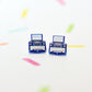 Typewriter shaped stud earrings on a white background with colourful shapes. The earrings are dark blue with silver coloured details.